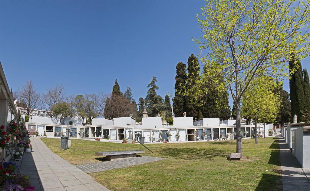 Plaça enjardinada amb un monument a les víctimes de la guerra situada a l’oest de la porta d’entrada.